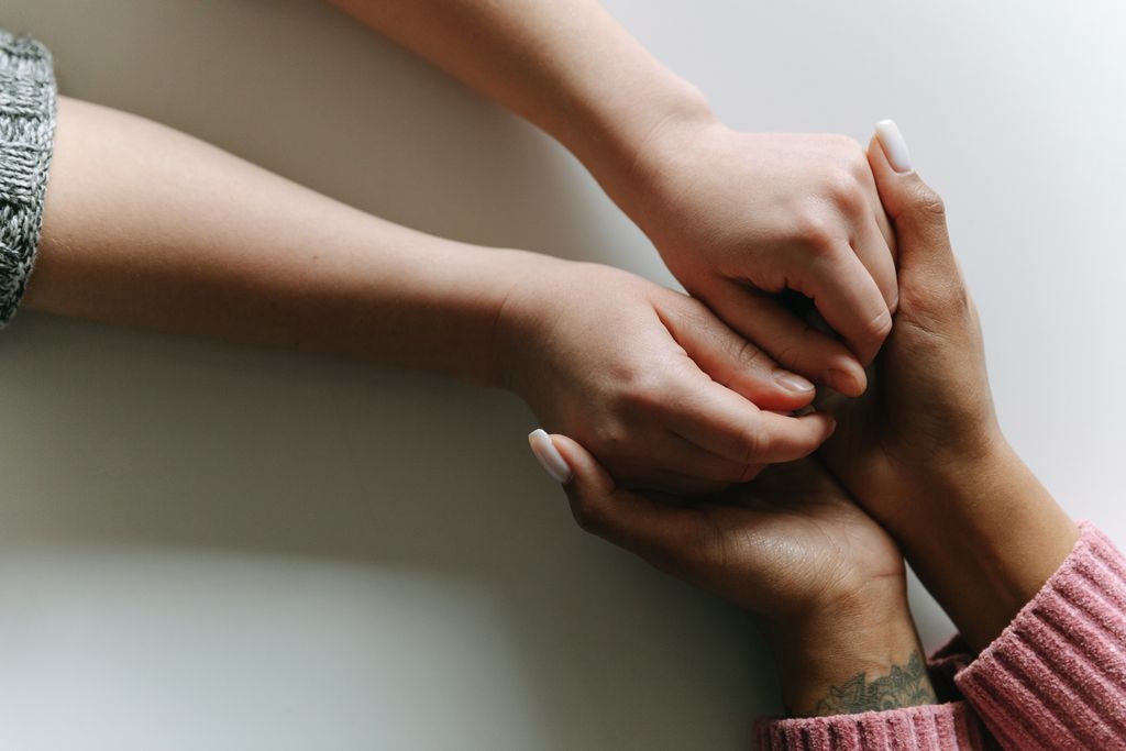 Close-up of diverse hands holding, symbolizing care, support, and friendship.
